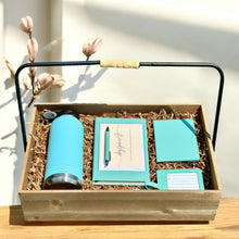  Gift set with teal tumbler, notebook, passport holder, greeting card, luggage tag, and pen in a wooden box.