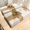 White gift boxes with burlap ribbons on a wooden surface